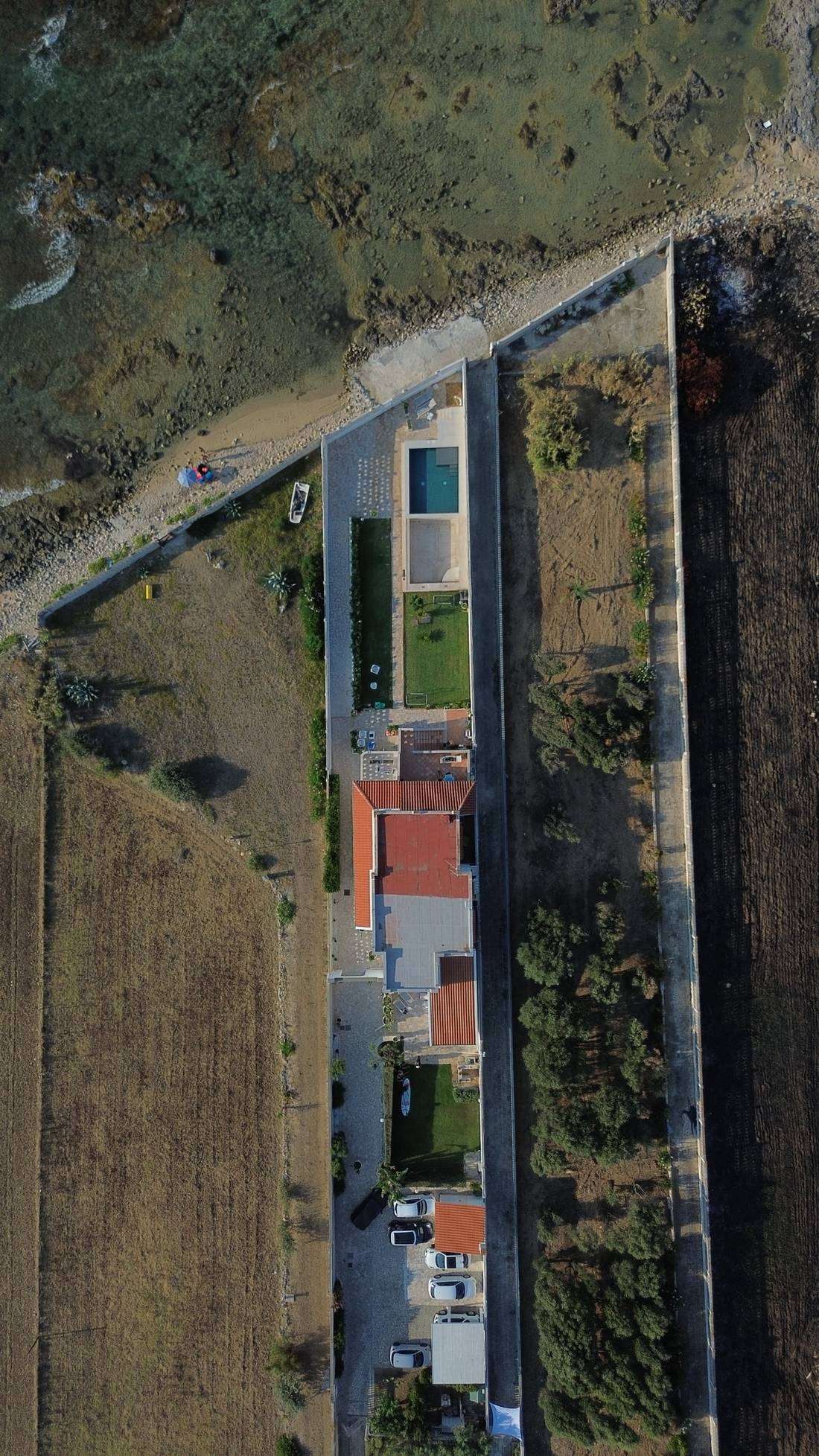 Vista dall'alto della casa: piscina, prato e giardino affacciati sulla costa