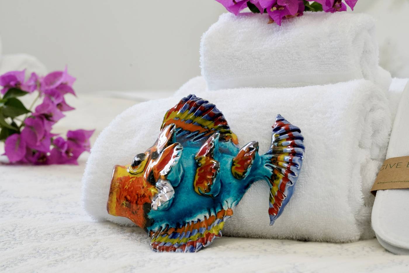 Pesce in ceramica colorata sugli asciugamani